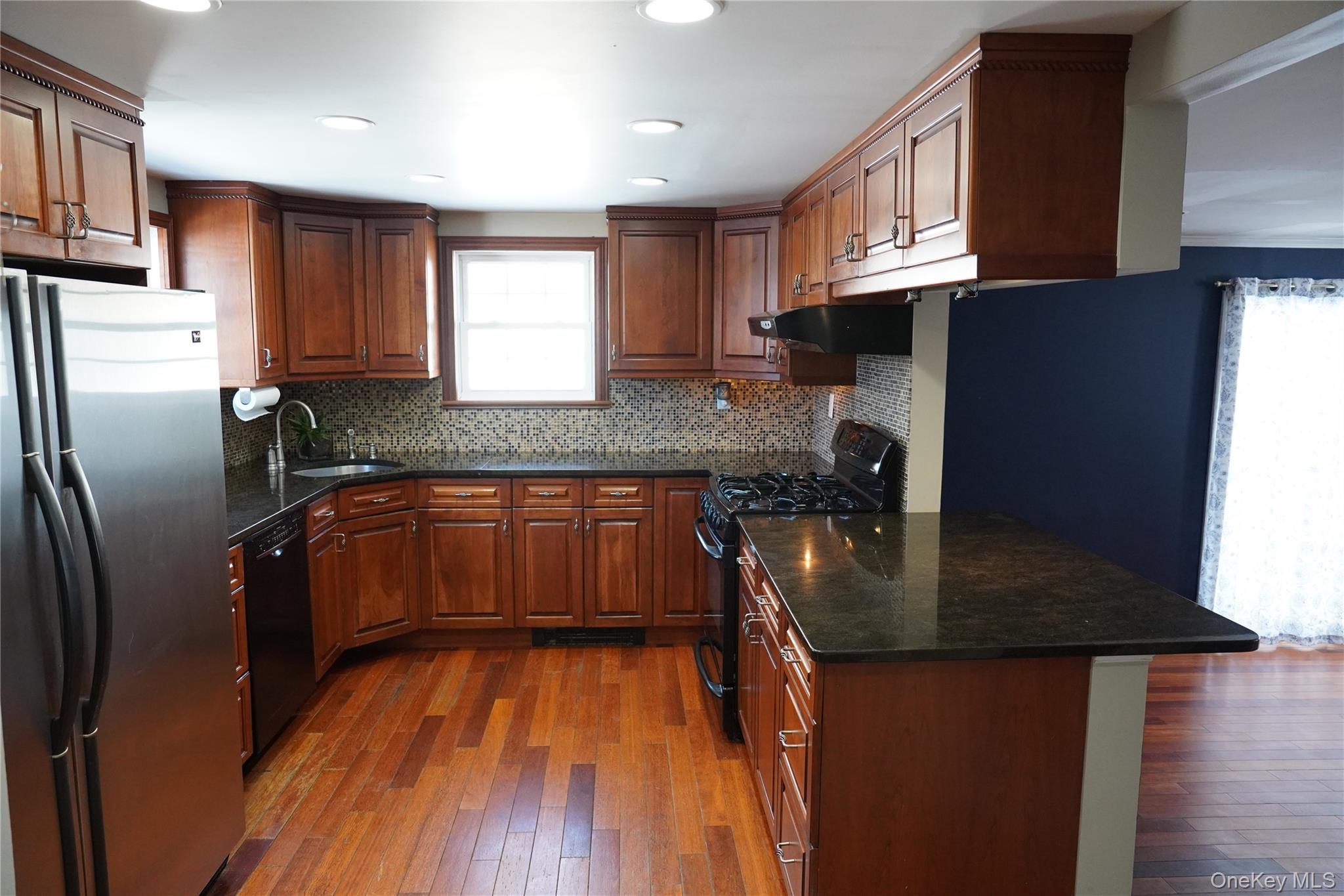 21 Potter Street Patchogue, NY 11772 - Photo 10 of 22 a kitchen with stainless steel appliances granite countertop a sink refrigerator and cabinets
