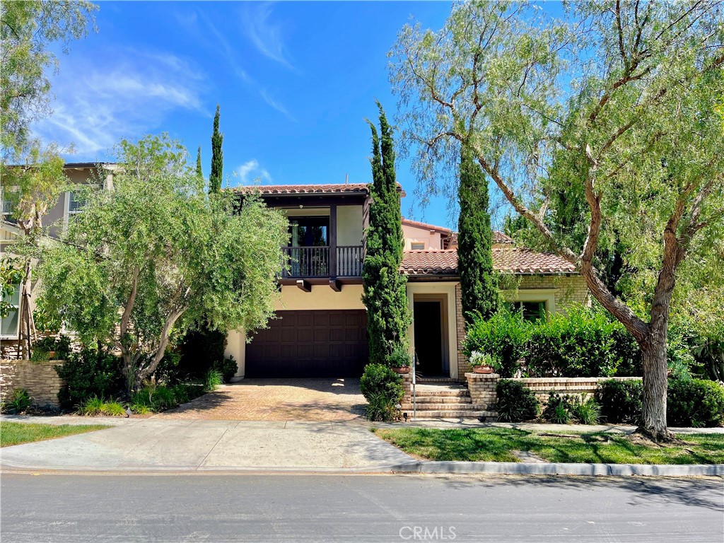 a front view of a house with a yard and tree
