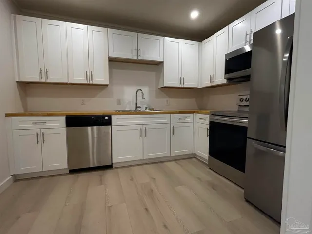 a kitchen with stainless steel appliances granite countertop a stove top oven a sink and dishwasher