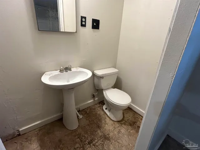 a bathroom with a toilet sink and mirror