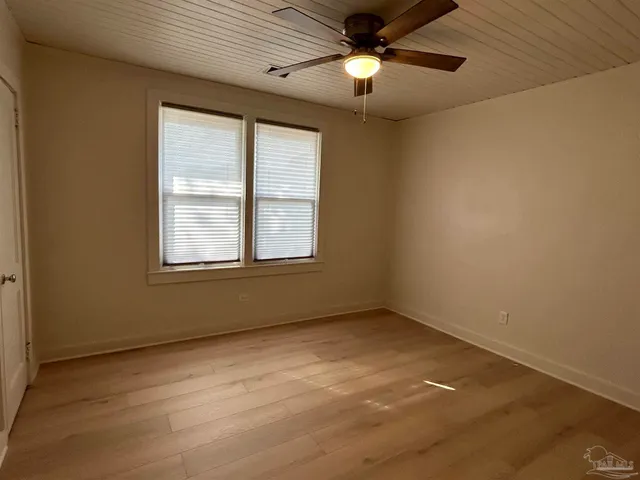 an empty room with a window and a fan