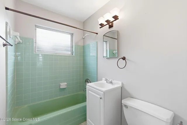 a bathroom with a toilet sink vanity tub and shower