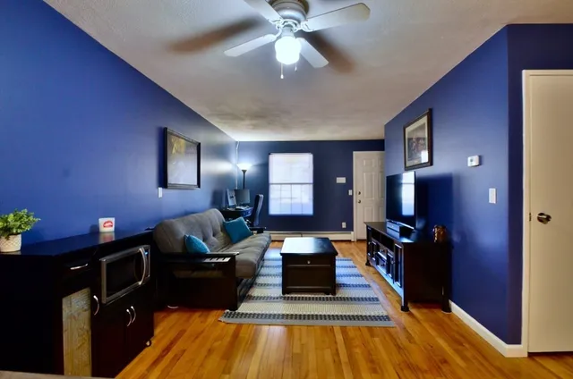 a living room with furniture and wooden floor