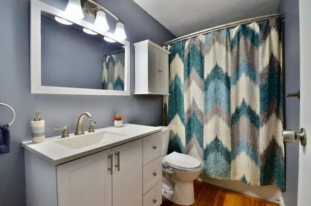a bathroom with a sink and mirror with toilet