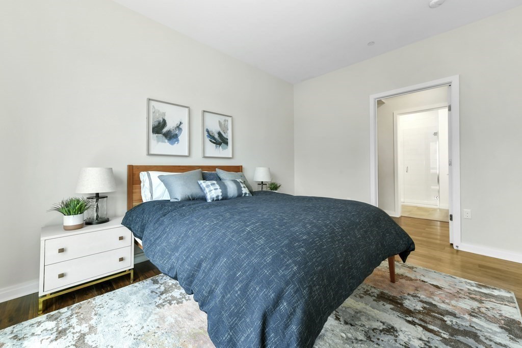 3531 Washington Street, Unit 226 Boston, MA 02130 - Photo 11 of 35 a bedroom with a bed and wooden floor
