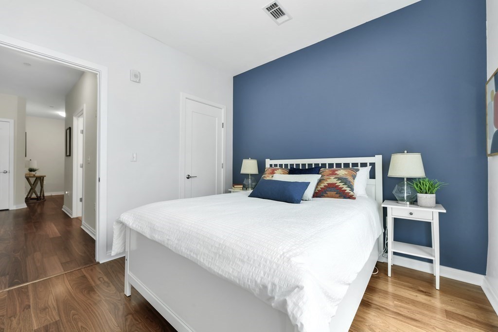 3531 Washington Street, Unit 226 Boston, MA 02130 - Photo 16 of 35 a bedroom with a bed and wooden floor
