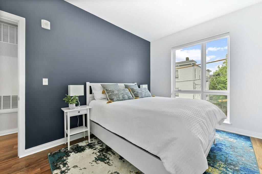 3531 Washington Street, Unit 226 Boston, MA 02130 - Photo 17 of 35 a bedroom with a bed and wooden floor