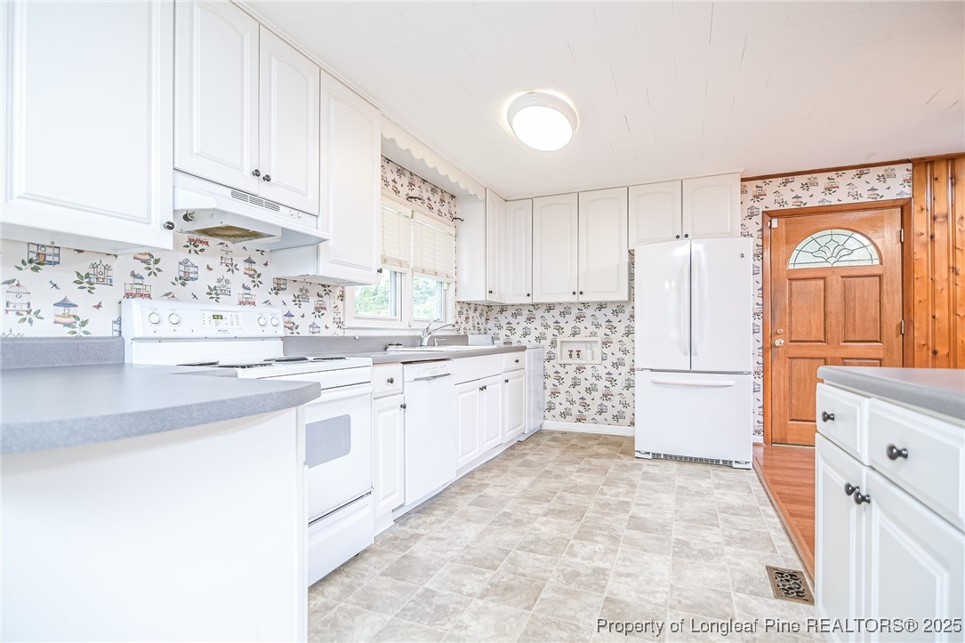 2067 Wade-Stedman Road Stedman, NC 28391 - Photo 14 of 29 a kitchen with granite countertop white cabinets and white appliances