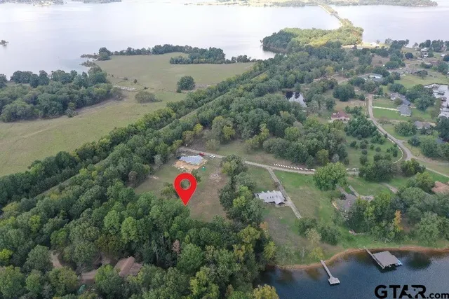 an aerial view of a house with a yard and lake view