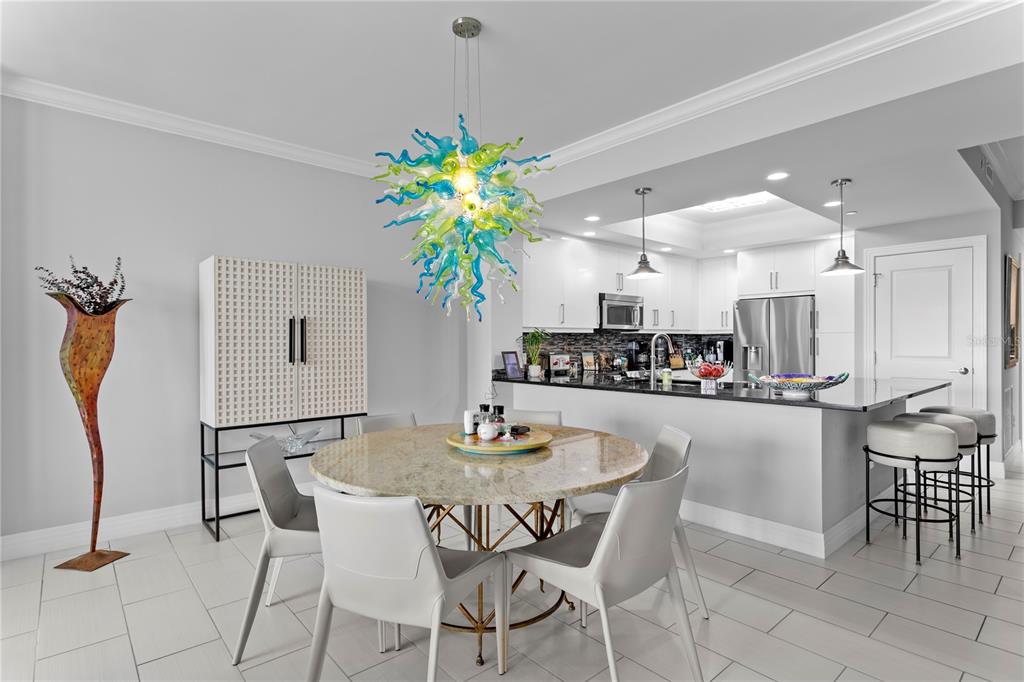 1325 Snell Isle Boulevard Northeast, Unit 711 St. Petersburg, FL 33704 - Photo 16 of 37 a dining room filled chandelier and kitchen view