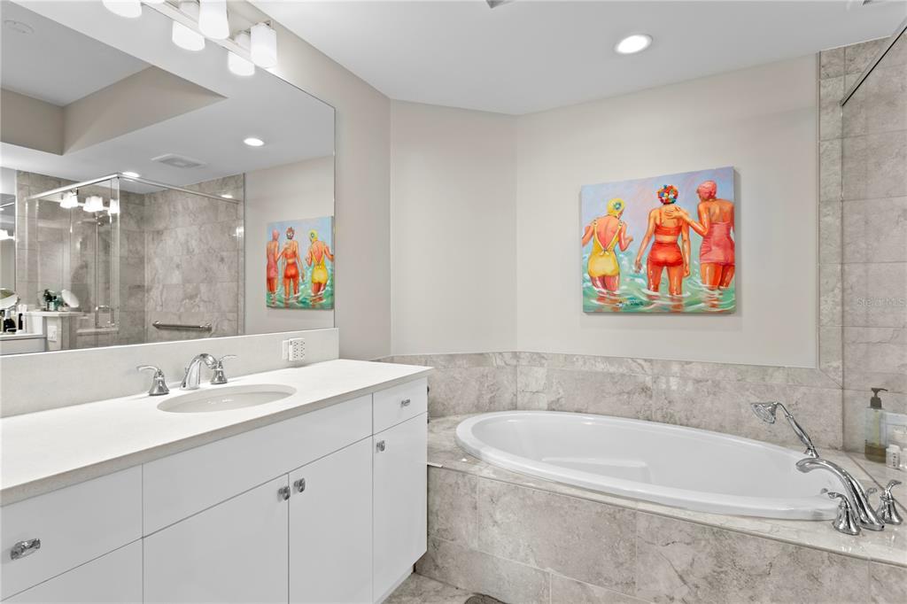 1325 Snell Isle Boulevard Northeast, Unit 711 St. Petersburg, FL 33704 - Photo 22 of 37 a bathroom with a sink a large mirror and a bathtub