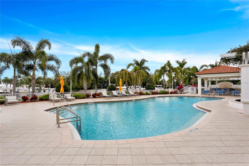1325 Snell Isle Boulevard Northeast, Unit 711 St. Petersburg, FL 33704 - Photo 35 of 37 a view of swimming pool with outdoor seating and house in the background