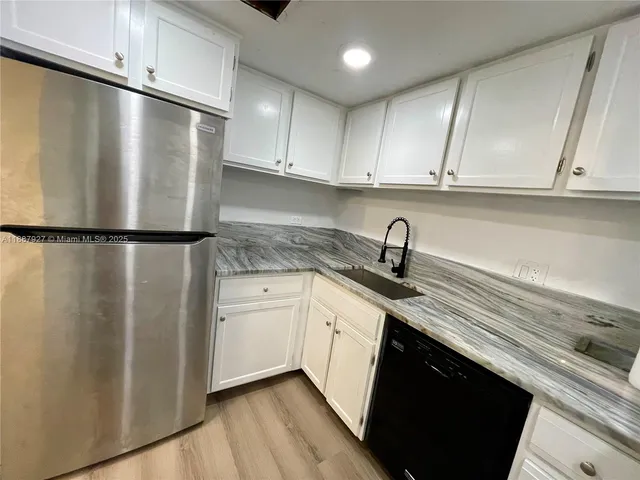 a kitchen with stainless steel appliances a refrigerator and cabinets