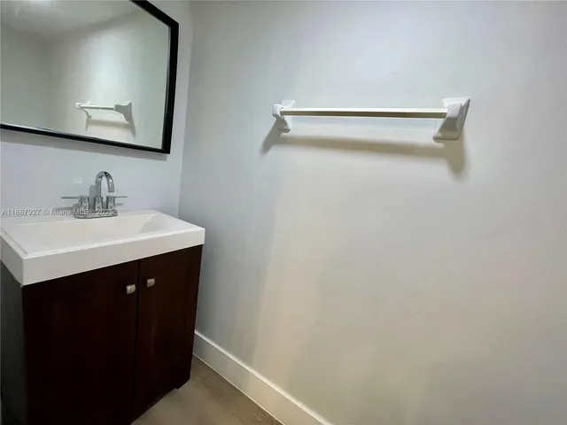 a bathroom with a sink vanity and mirror