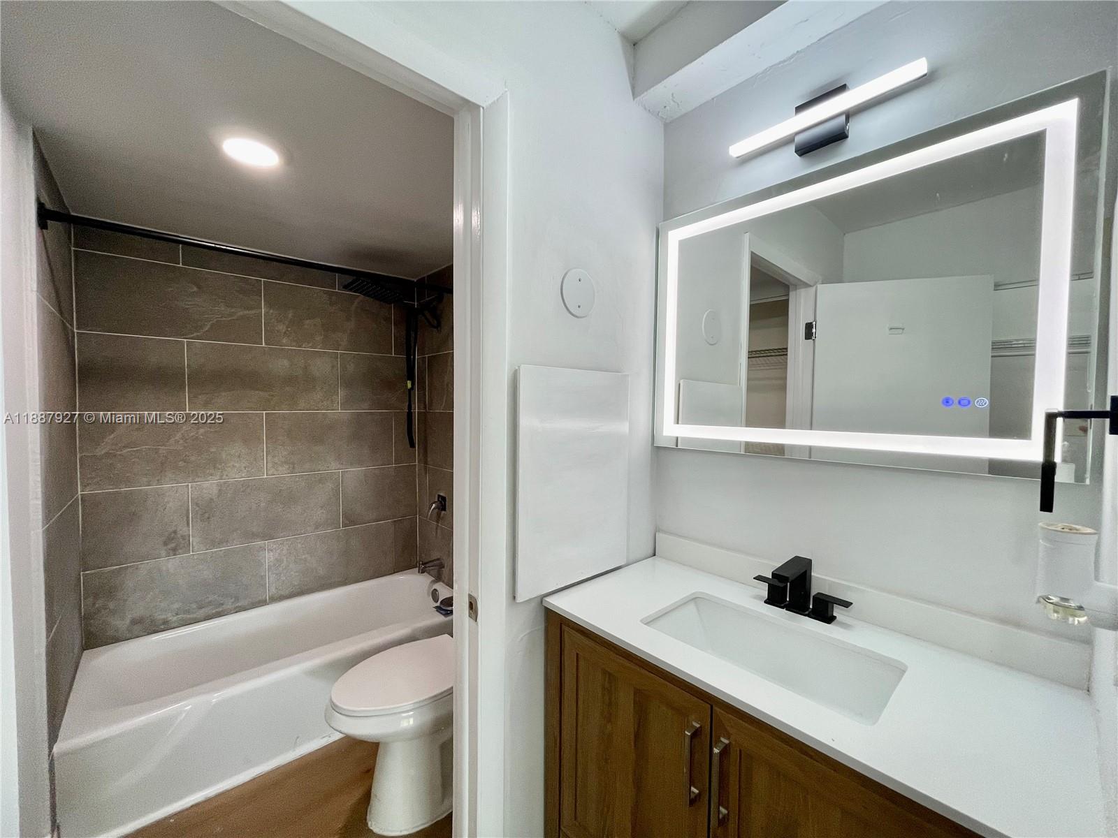 3680 Inverrary Drive, Unit 2B Lauderhill, FL 33319 - Photo 10 of 12 a bathroom with a sink a toilet and shower