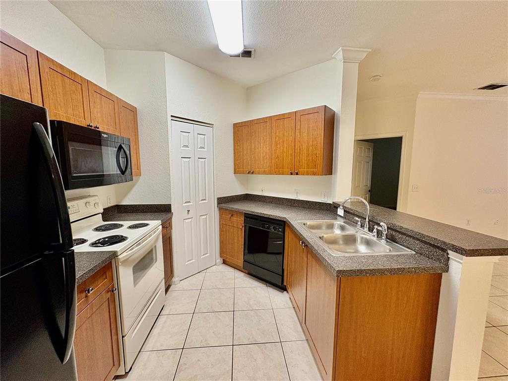 2199 Chianti Place, Unit 912 Palm Harbor, FL 34683 - Photo 3 of 20 a kitchen with stainless steel appliances granite countertop a stove top oven microwave and refrigerator