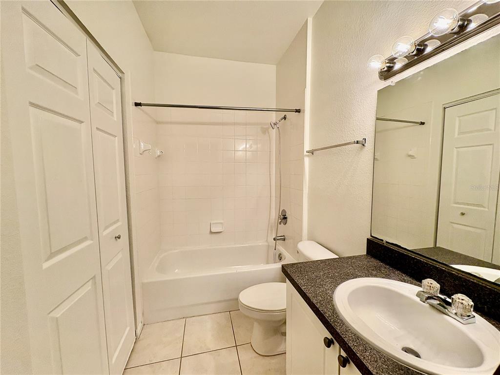 2199 Chianti Place, Unit 912 Palm Harbor, FL 34683 - Photo 8 of 20 a bathroom with a granite countertop sink toilet and shower
