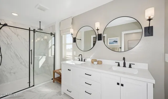 a bathroom with a double vanity sink mirror and bathtub