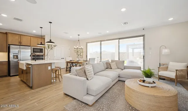 a kitchen with stainless steel appliances a table chairs sink refrigerator and microwave