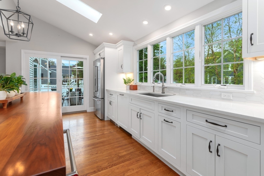 32 Sturges Road Reading, MA 01867 - Photo 12 of 39 a large kitchen with sink a large window and a wooden floor