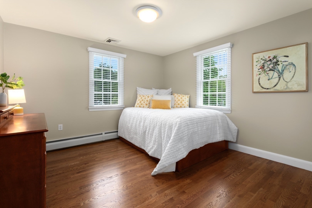 32 Sturges Road Reading, MA 01867 - Photo 24 of 39 a bedroom with a bed and wooden floor