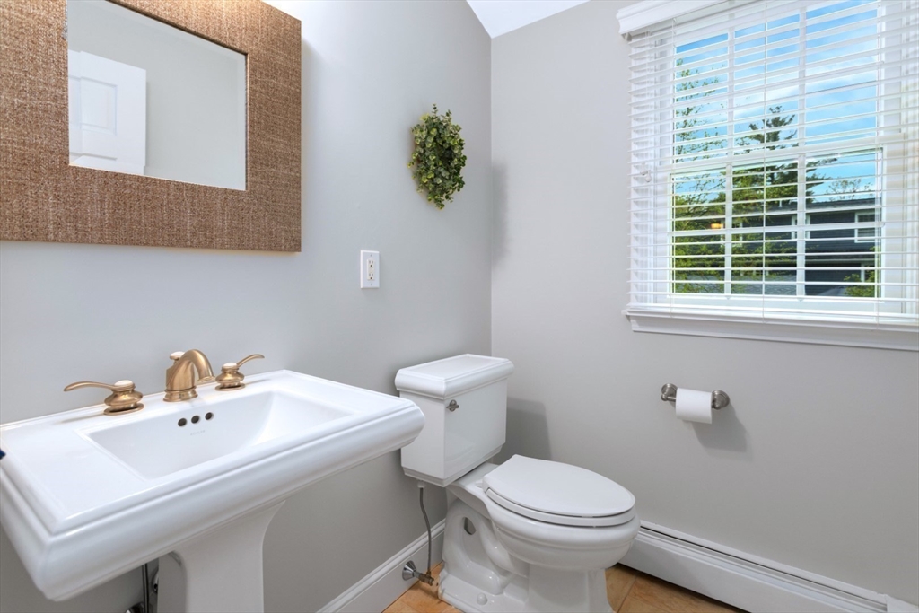 32 Sturges Road Reading, MA 01867 - Photo 27 of 39 a bathroom with a sink a toilet and a mirror