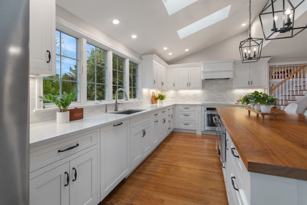 32 Sturges Road Reading, MA 01867 - Photo 8 of 39 a large kitchen with kitchen island a large window in it