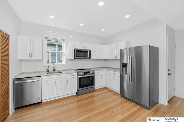 a kitchen with stainless steel appliances granite countertop a refrigerator stove and sink