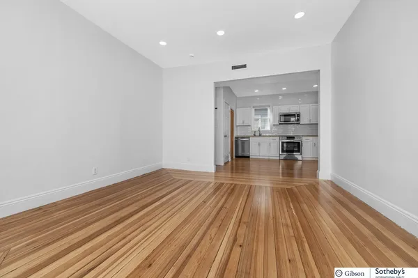 a view of a room with wooden floor and electronic appliances