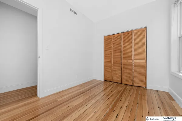 an empty room with wooden floor and closet