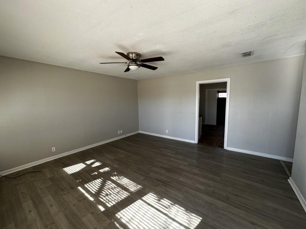 1602 39th Street Lubbock, TX 79412 - Photo 2 of 14 a view of a room with wooden floor and a ceiling fan