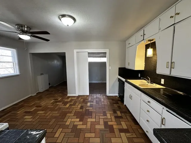 a large kitchen with stainless steel appliances a stove a sink a microwave and a refrigerator