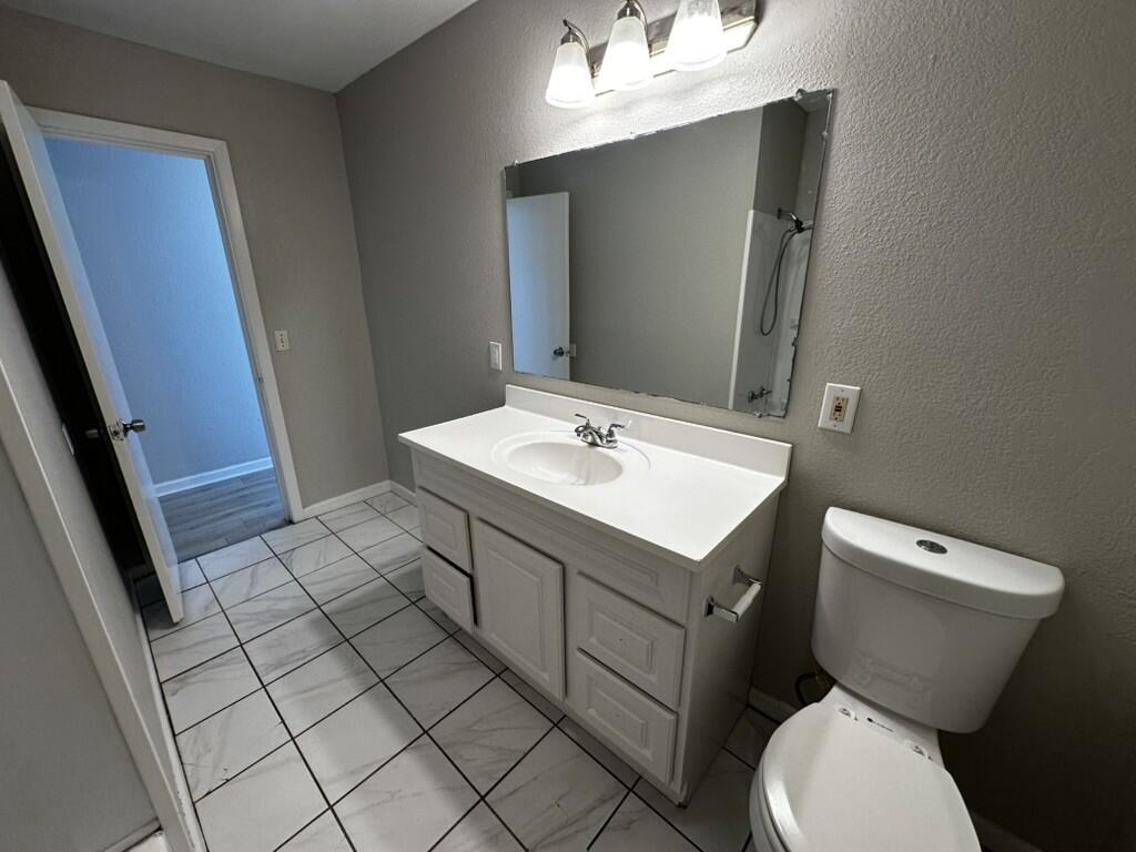 1602 39th Street Lubbock, TX 79412 - Photo 10 of 14 a bathroom with a sink toilet and mirror