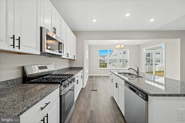 a kitchen with kitchen island granite countertop white cabinets and white appliances