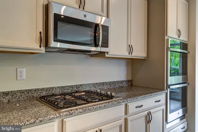 a kitchen with granite countertop a stove and a microwave