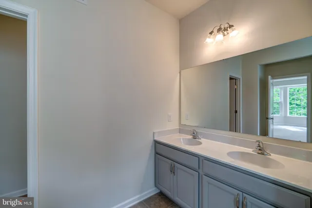 a bathroom with a double vanity sink and a mirror