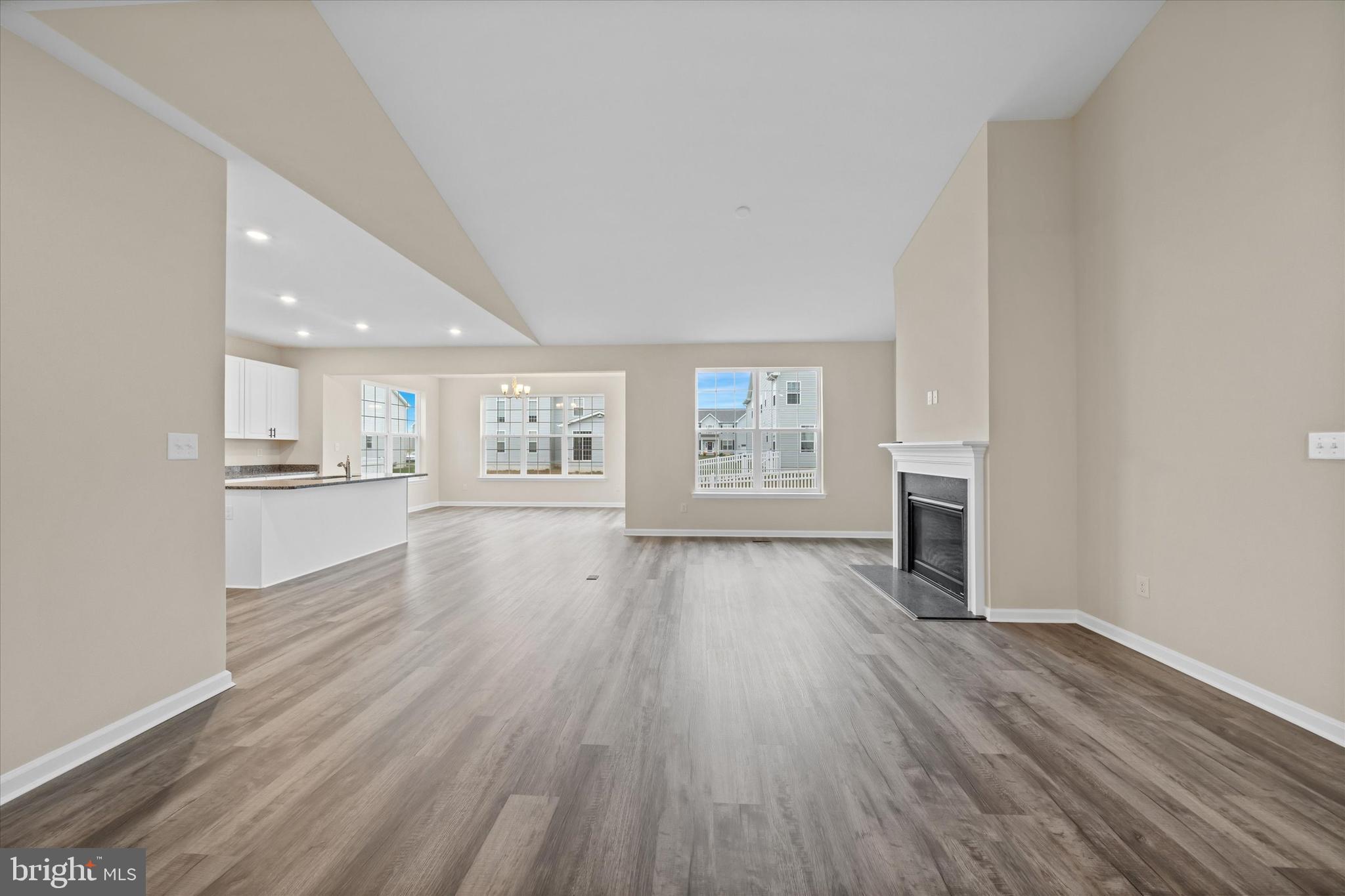 211 Laks Court, Unit JEFFERSON Smyrna, DE 19977 - Photo 19 of 22 an empty room with wooden floor and kitchen view
