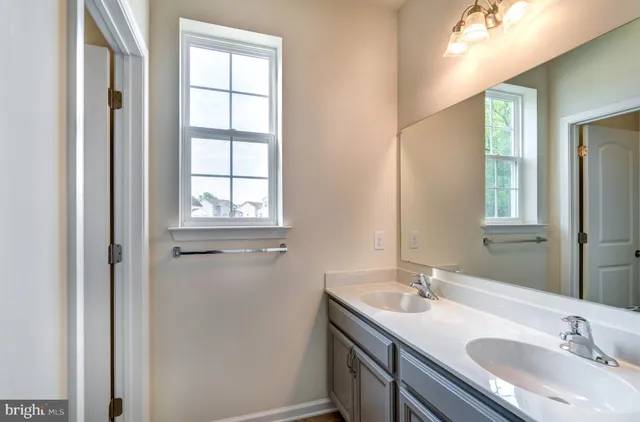a bathroom with 2 sink and a mirror