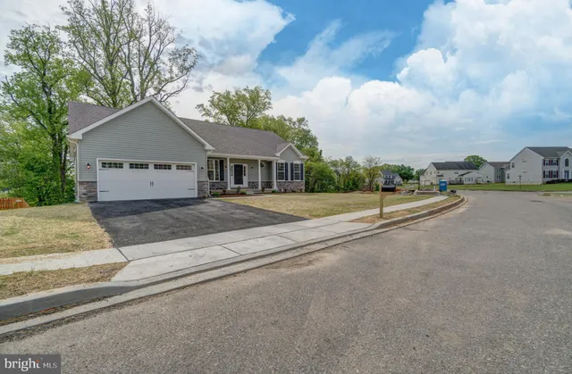 a view of a house with a yard and large trees