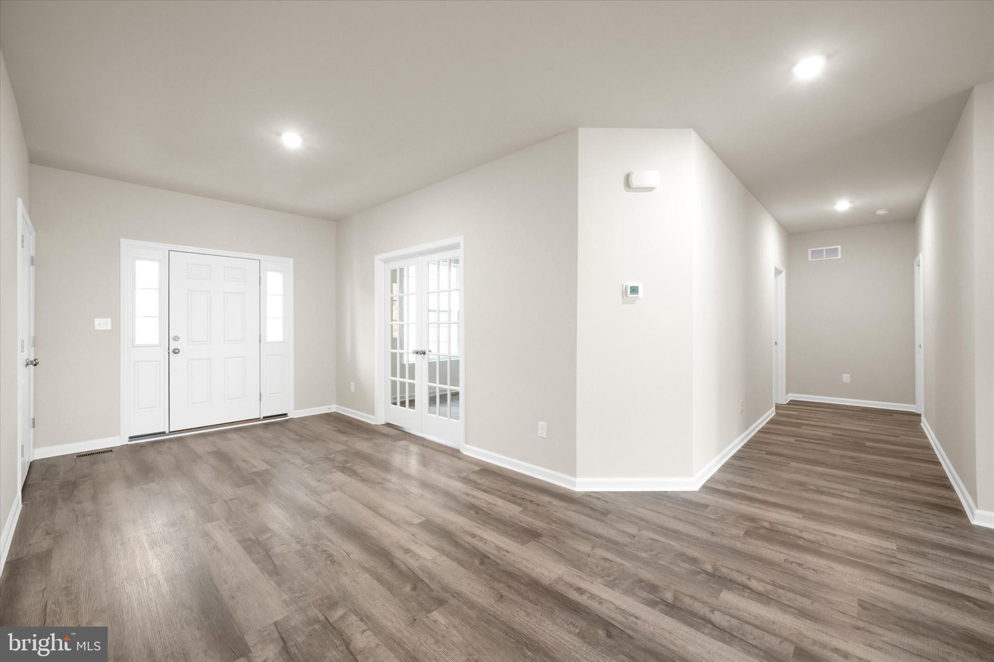 211 Laks Court, Unit JEFFERSON Smyrna, DE 19977 - Photo 5 of 22 a view of an empty room with wooden floor and a window