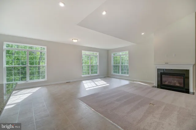 a view of an empty room with a window and a fireplace