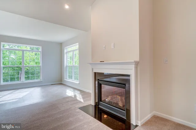 a view of an empty room with window and fire place