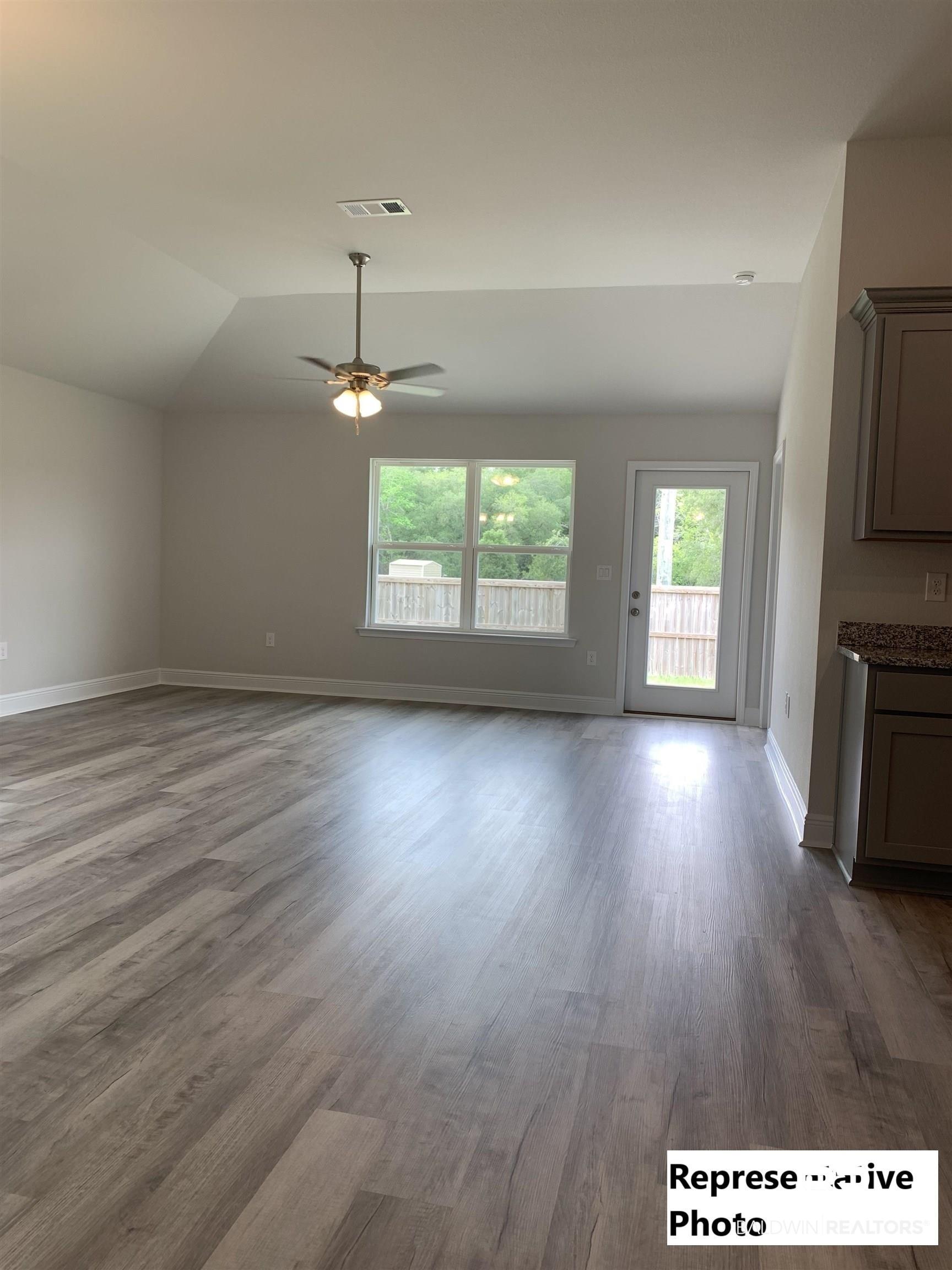 645 Revere Street Foley, AL 36535 - Photo 3 of 14 Unfurnished living room with ceiling fan, lofted ceiling, and hardwood / wood-style flooring