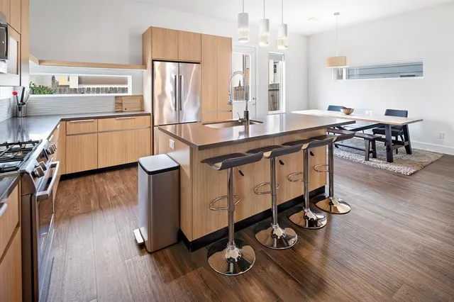 a kitchen with counter space dining table and wooden floor