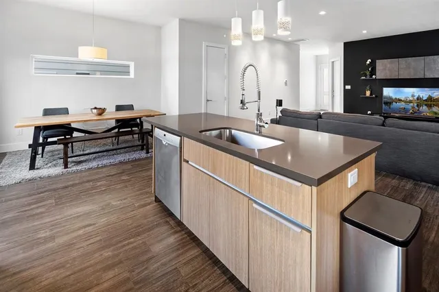 a kitchen with stainless steel appliances granite countertop a sink a stove and a wooden floors