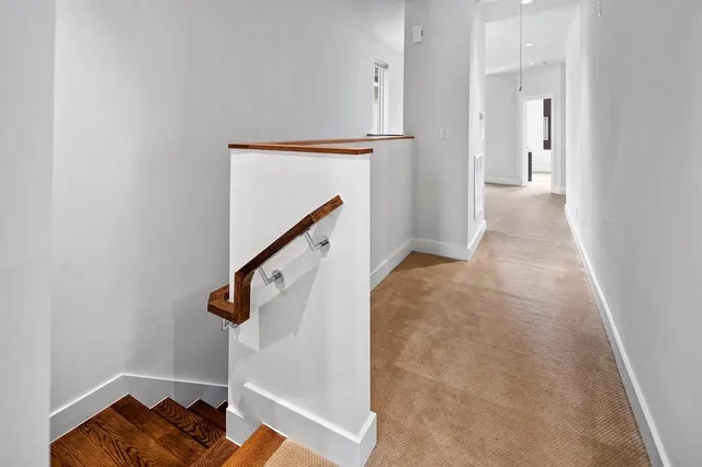 a view of a hallway with wooden floor and staircase