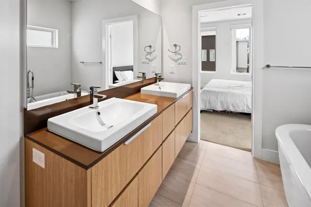 a en suite bathroom with a sink a mirror and a bathtub