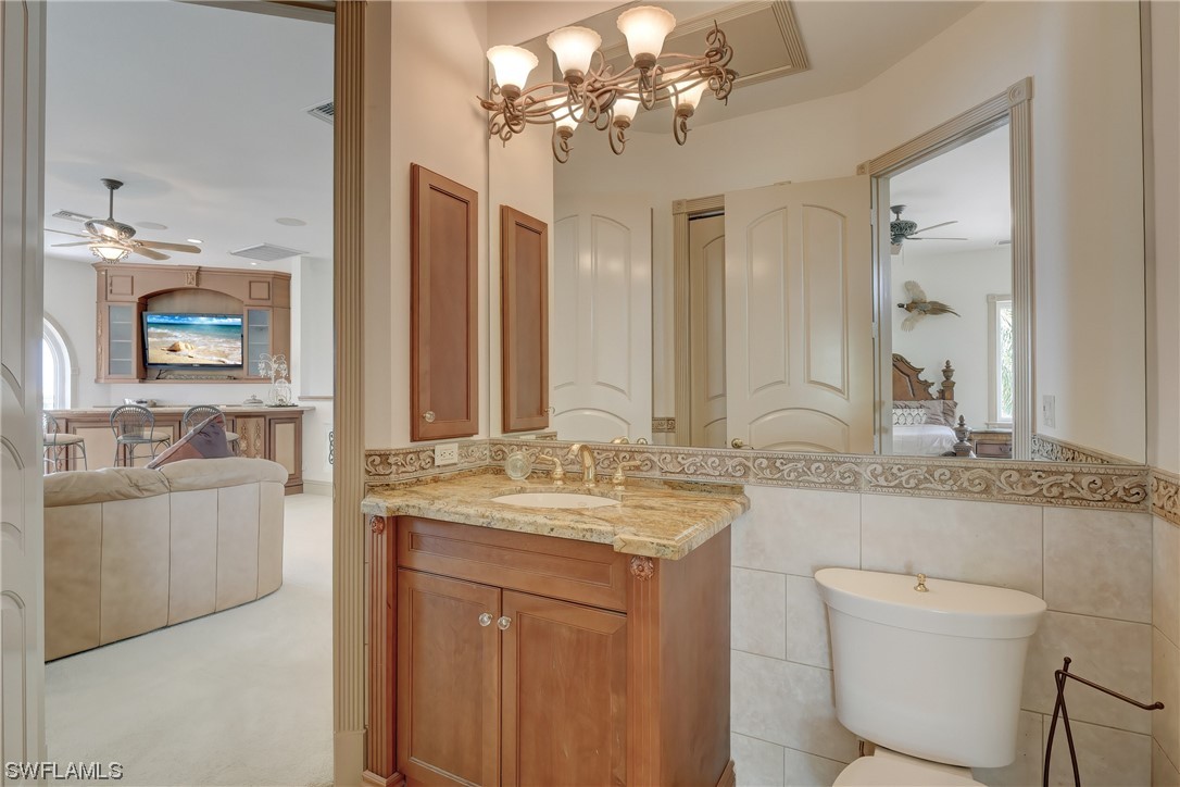 5960 Harborage Drive Fort Myers, FL 33908 - Photo 31 of 32 a bathroom with a granite countertop sink a large mirror a toilet and a bathtub