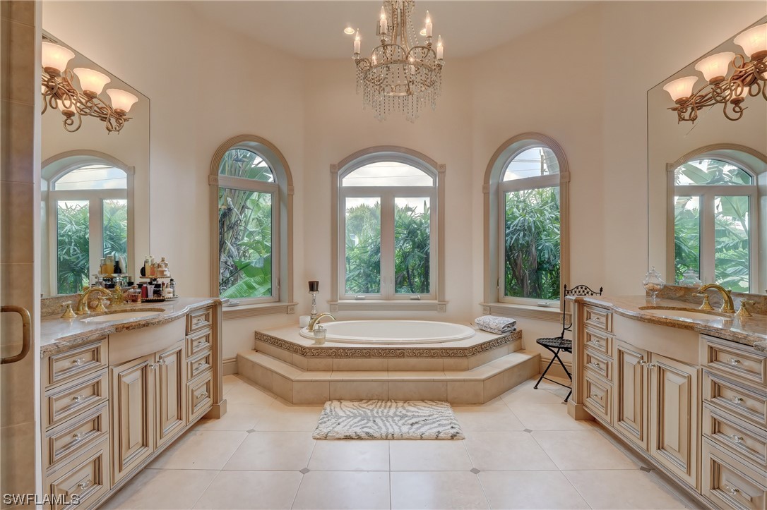 5960 Harborage Drive Fort Myers, FL 33908 - Photo 8 of 32 a spacious bathroom with sinks a large mirror and a bathtub next to a window