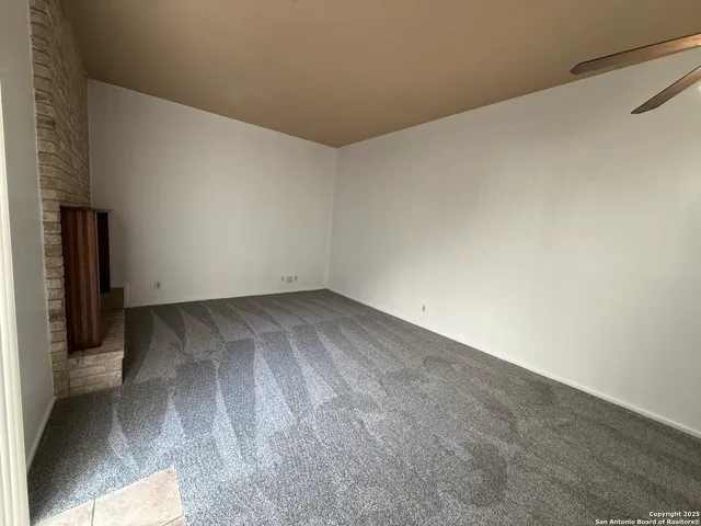 an empty room with windows and fireplace